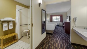 A hotel room with a shower, a bed, a bedside table, a mirror, a window with curtains, and a bathroom with a sink and towel rack. - Best Western Falcon Plaza - Bowling Green (Bowling Green)