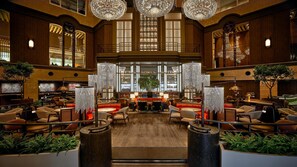 Un vestíbulo espacioso con techos altos, candelabros ornamentales y una zona de bar central.