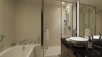 A modern bathroom with a bathtub, shower, and sink.