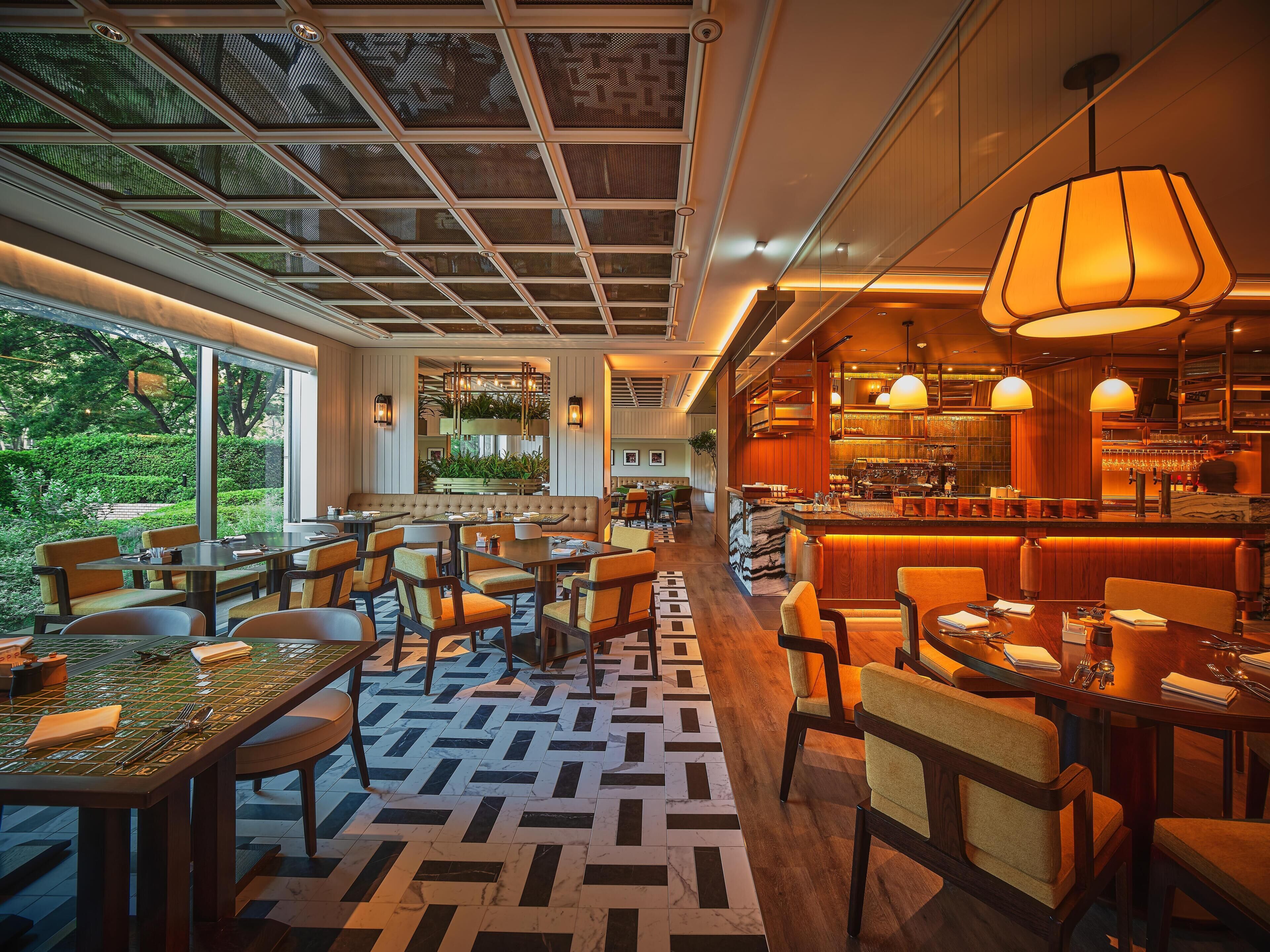 A restaurant with a bar area, dining tables, and chairs.
