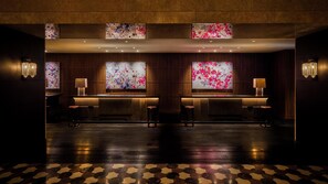 A reception area with a wooden reception desk, two chairs, and a patterned floor. - Hyatt Regency Tokyo (Tokyo)