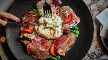 A plate of food with various meats, vegetables, and a fork.