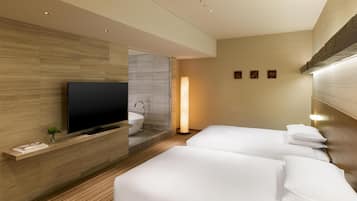 A hotel room with a flat-screen TV, a large window, a sink, and two beds.