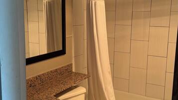 A bathroom with a toilet, sink, and shower.
