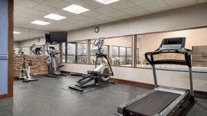 A gym with treadmills, elliptical machines, and stationary bikes.