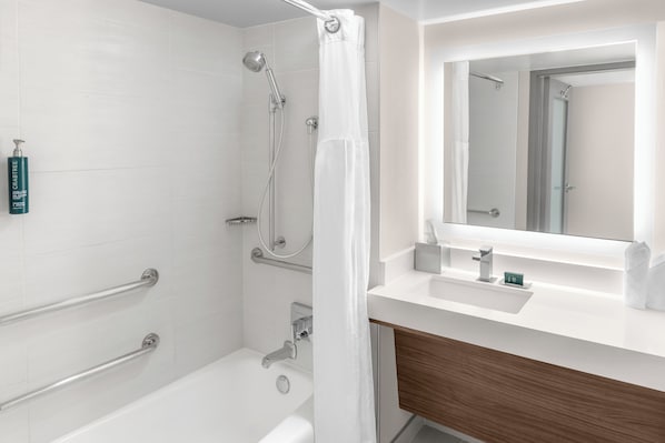 A modern bathroom with a bathtub, shower, and vanity. - DoubleTree by Hilton New Orleans (New Orleans)