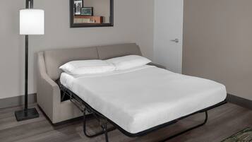 Un dormitorio moderno con cama, lámpara de pie, espejo y puerta.