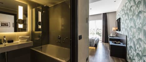 A modern bathroom with a bathtub, a shower, and a vanity with a mirror.