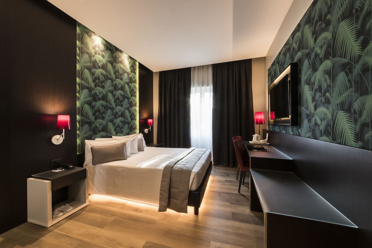 Une chambre d’hôtel moderne avec un grand lit, un bureau et une télévision.