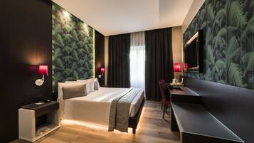 Una camera d'albergo moderna con un letto grande, una scrivania e una televisione.