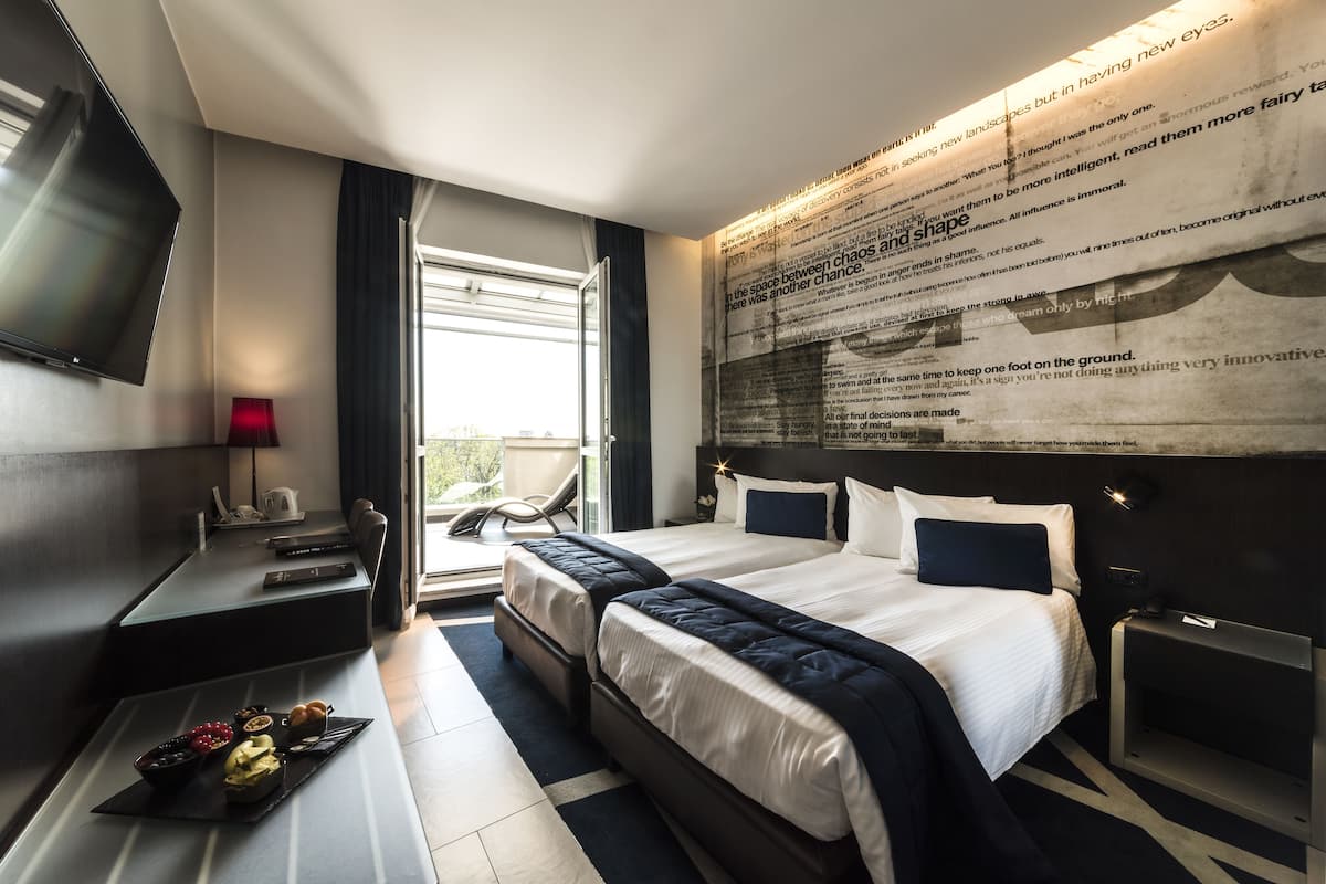Une chambre d’hôtel moderne équipée d’un grand lit, d’un bureau et d’un téléviseur à écran plat.
