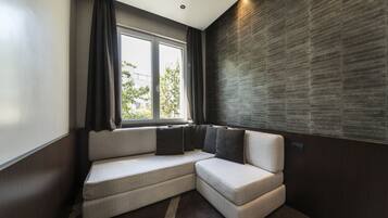 Un interior moderno con un sofá modular, ventanas amplias y una pared con textura.