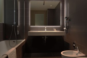 Un bagno moderno con doccia vetrata, uno specchio grande e un lavabo con bidet.