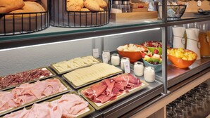 A buffet with various food items including bread, pastries, meats, cheeses, and fruits. - Sercotel Togumar (Madrid)