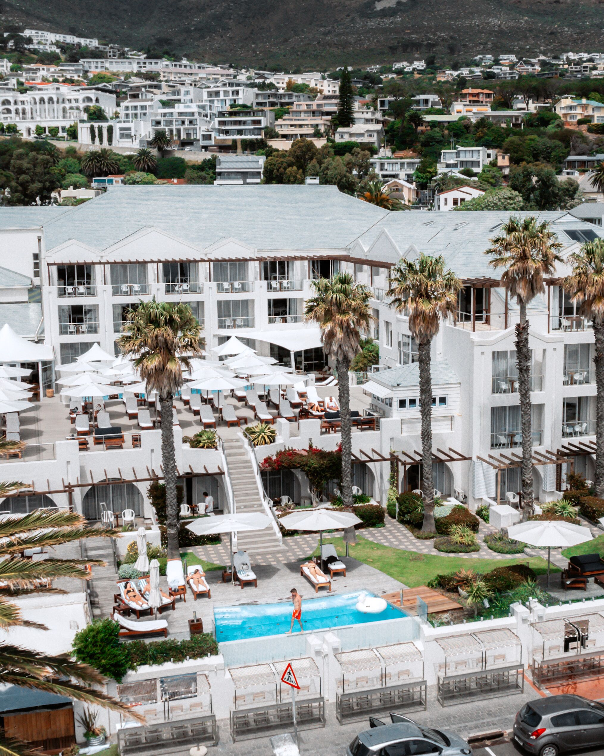 A hotel with multiple floors, outdoor pool, and palm trees.