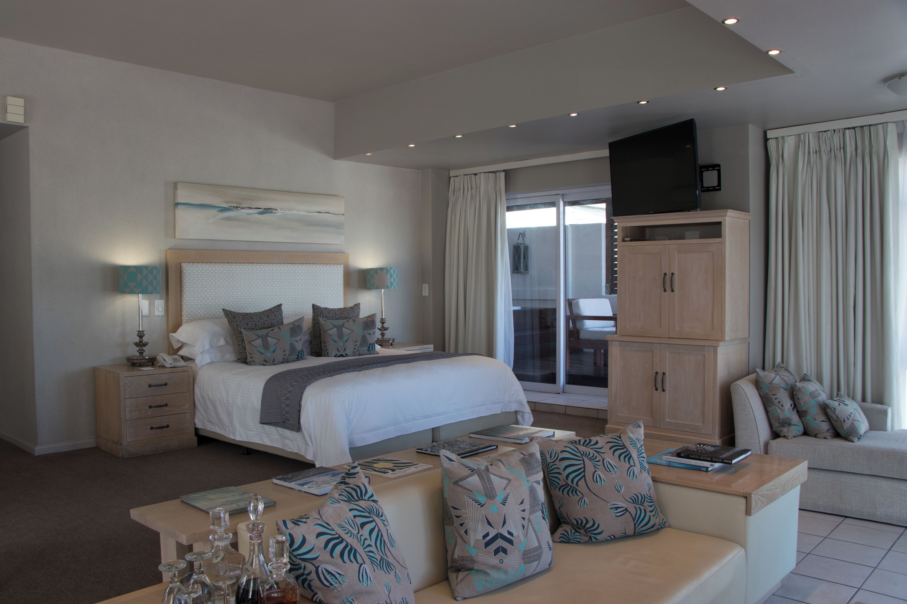 Une chambre avec un grand lit, un canapé, une télévision et une armoire.