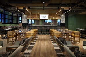 A conference room with multiple tables and chairs, a large screen displaying 'Spirited Classics', and a bar area in the background. - Washington Marriott at Metro Center (Washington)