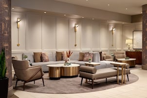 Ein modernes Wohnzimmer mit einem Ecksofa, Sesseln, einem Couchtisch und einem Beistelltisch.