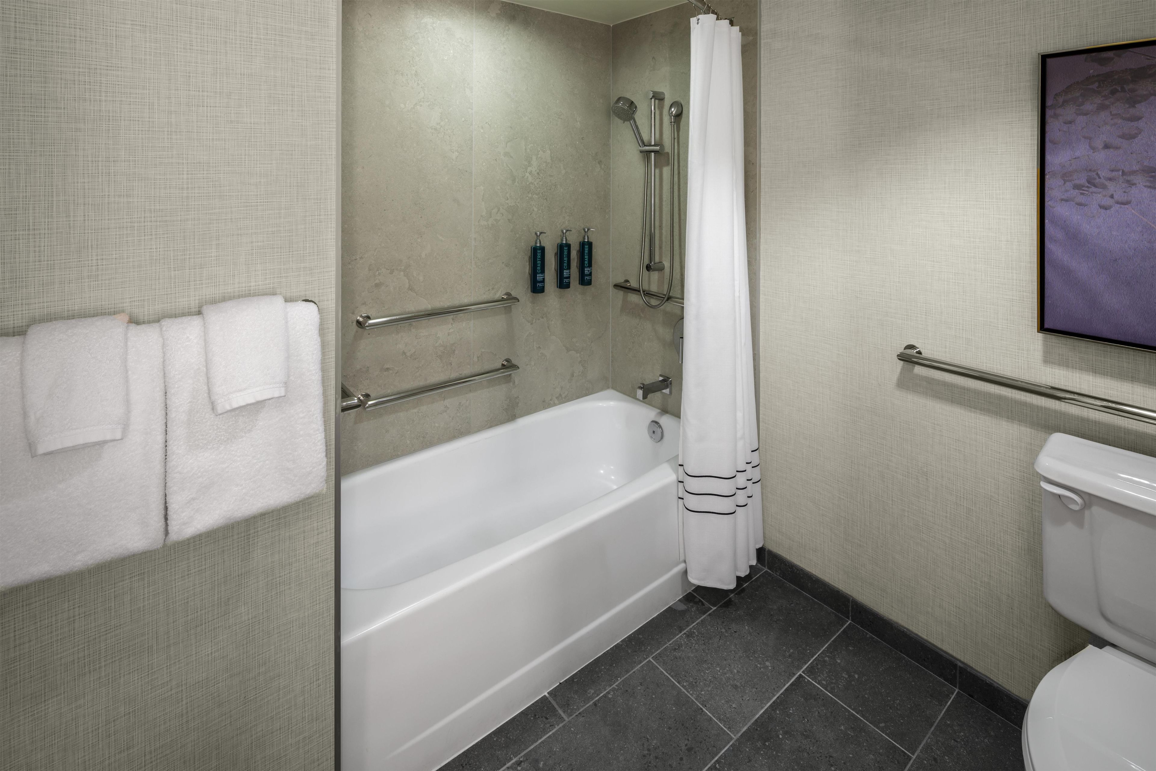 A bathroom with a bathtub, toilet, and shower.