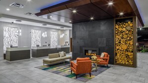 A modern lobby with a reception desk, sofas, a fireplace, and a decorative wall. - DoubleTree by Hilton Rochester (Rochester)