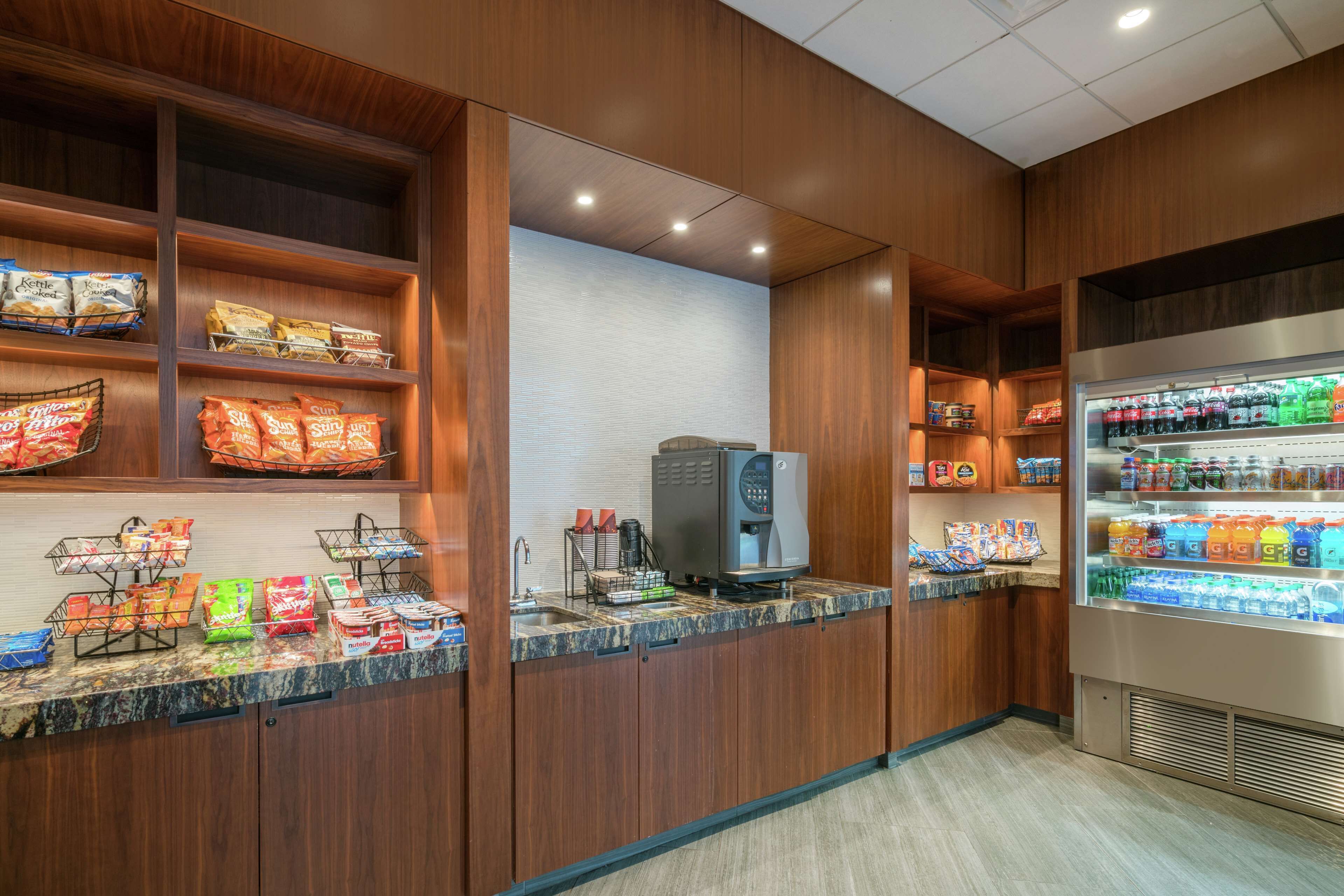 Un distributeur de boissons en libre-service, doté d’un présentoir réfrigéré et d’une machine à café.