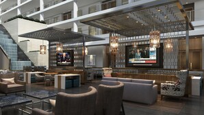 A modern hotel lobby with a bar area, seating arrangements, and a large screen displaying news. - Embassy Suites by Hilton Washington DC Georgetown (Washington)