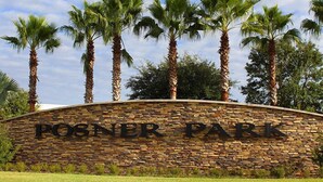 A stone wall with the text "POSNER PARK" and palm trees in the background.