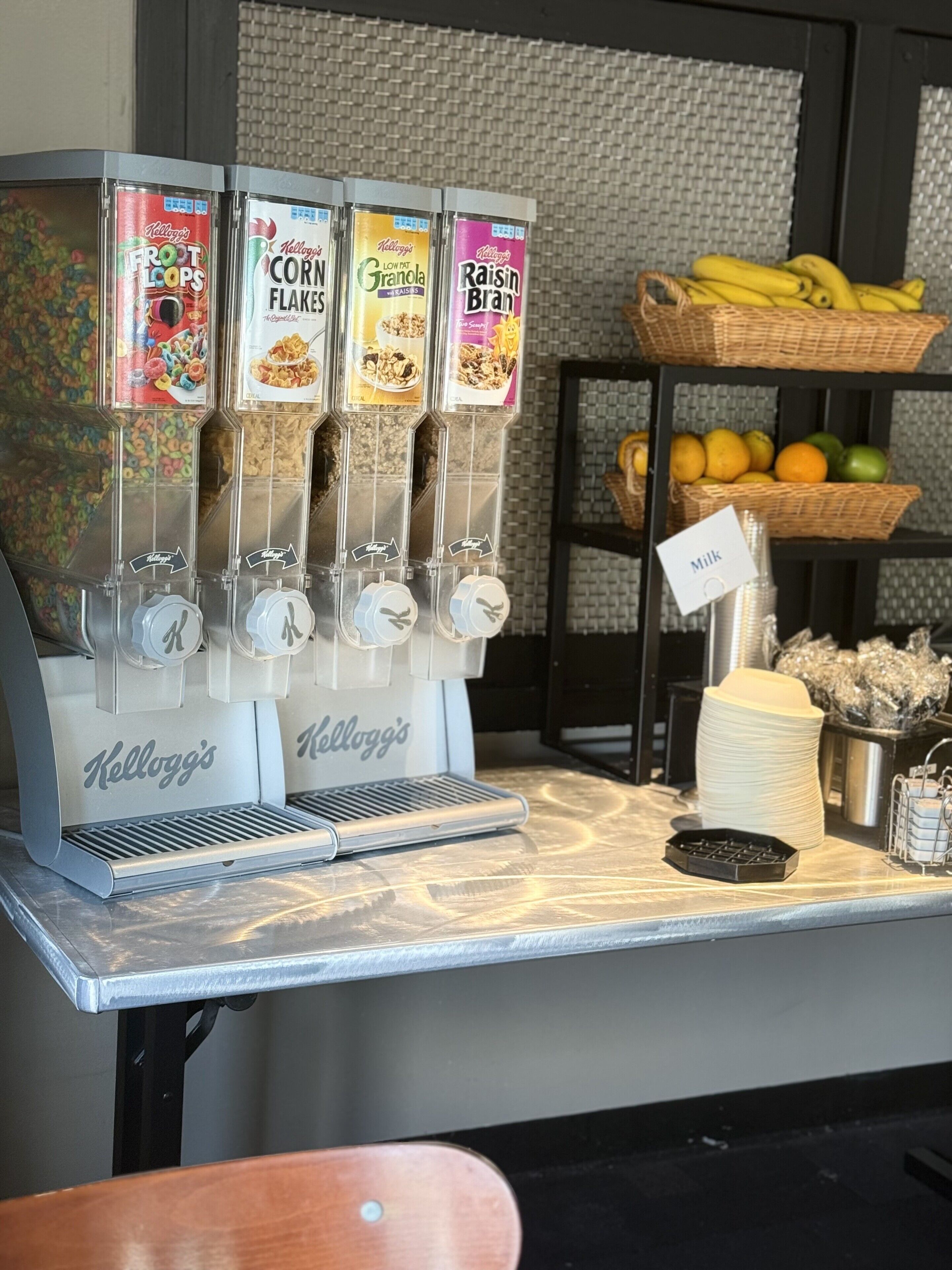 A beverage dispenser with multiple options including Froot Loops, Corn Flakes, Low Fat Granola, and Raisin Bran.
