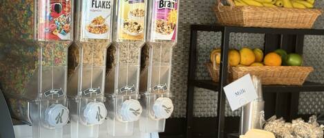 A beverage dispenser with multiple options including Froot Loops, Corn Flakes, Low Fat Granola, and Raisin Bran.