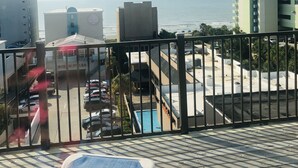 Un balcó amb vistes al mar, una piscina i una zona d'aparcament.