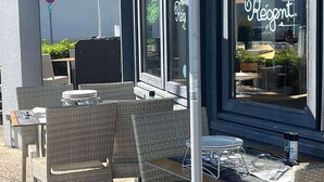 An outdoor seating area with wicker chairs and tables, a no parking sign, and a bistro sign. - ibis Tours Nord (Tours)
