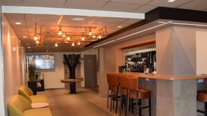 A modern bar area with stools, a counter, and a seating area with chairs. - ibis Tours Nord (Tours)