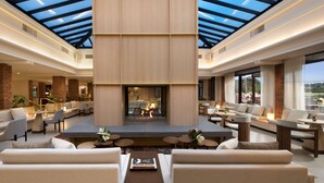Un vaste espace intérieur doté d’un haut plafond, d’un foyer central et de plusieurs coins salon.