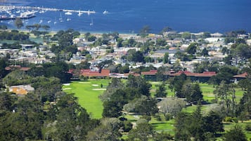 Uma cidade costeira com um porto de iates, edifícios residenciais e um campo de golfe.