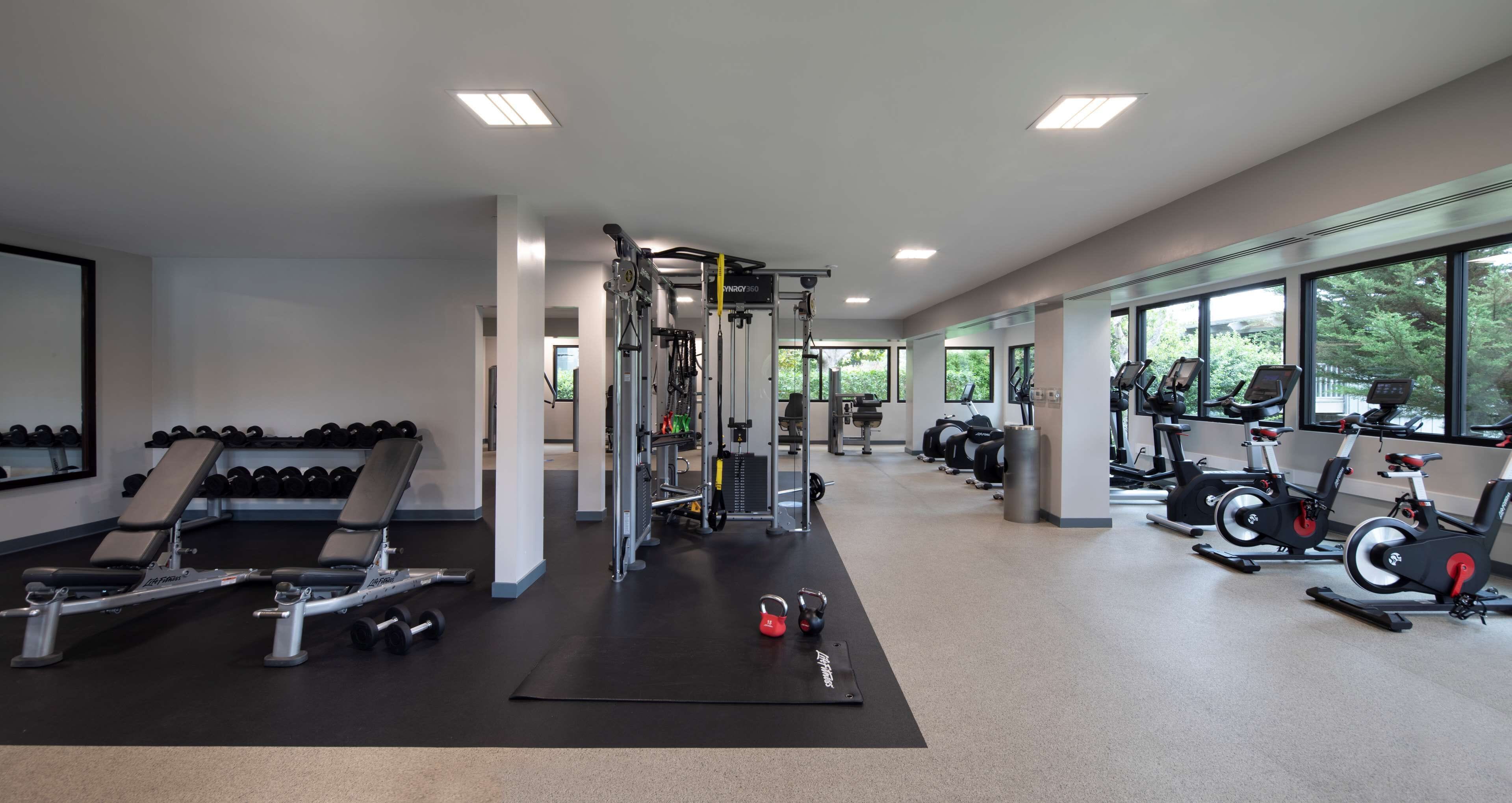Een fitnessruimte met krachtapparaten, gewichten en cardio-apparatuur.