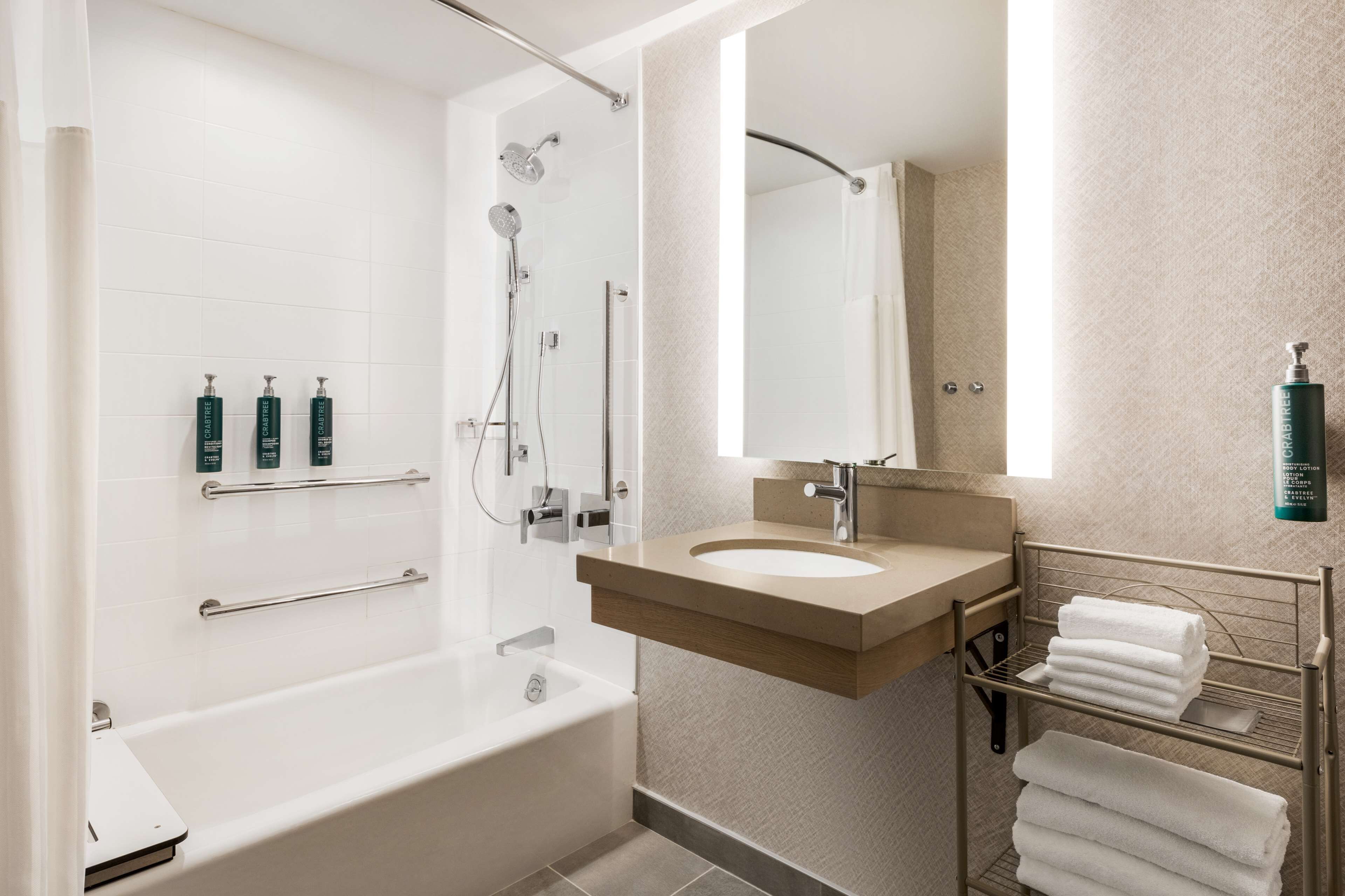 Une salle de bain moderne équipée d’une baignoire, d’une douche, d’un meuble-lavabo et d’un porte-serviettes.