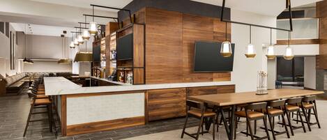 A modern kitchen with a central island, bar seating, and pendant lighting.