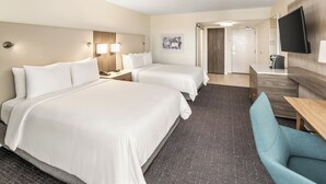 A hotel room with two beds, a desk, a chair, a flat-screen TV, and a door leading to a bathroom. - Crowne Plaza Orlando - Lake Buena Vista  by IHG (Orlando)