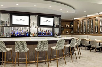 A reception desk with a modern design, two computer monitors, a small plant, and a pet feeding station. at Crowne Plaza Orlando - Lake Buena Vista by IHG