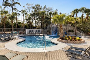 Una piscina al aire libre, sillones reclinables de piscina
