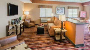 A hotel lobby with a seating area, a reception desk, and a television. - Comfort Inn - NYS Fairgrounds (Syracuse)