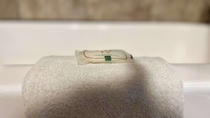 Une serviette blanche avec une étiquette sur une surface blanche.