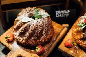 A bundt cake with strawberries and mint leaves on a wooden board. - Vienna House Easy by Wyndham Cracow (Kraków)