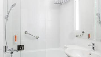 Un baño moderno con cabina de ducha de vidrio, un lavamanos blanco y bañera con mampara de vidrio.