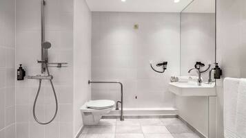 Un baño moderno con ducha, inodoro y lavamanos.