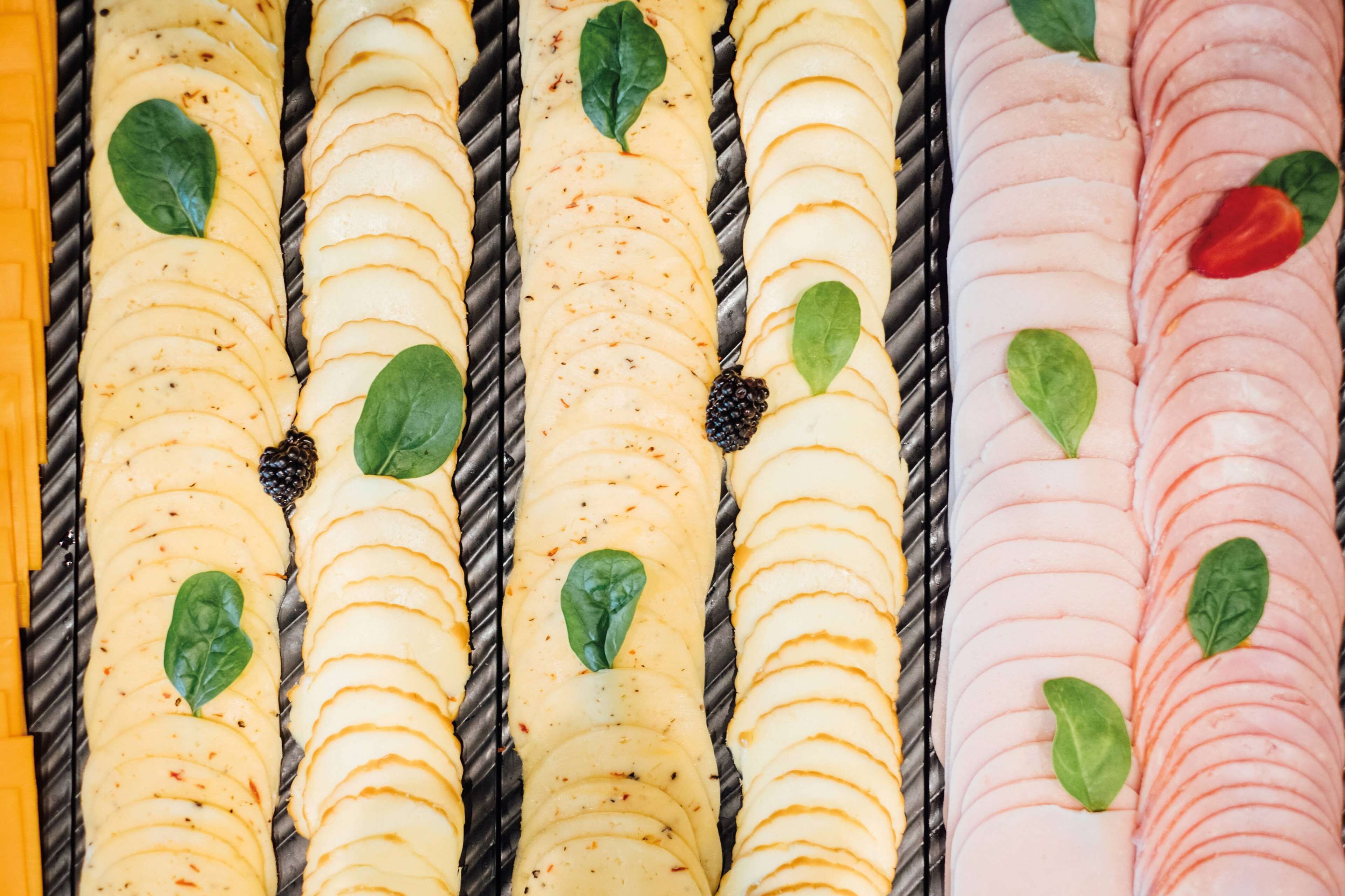 A close-up of sliced fruits and vegetables arranged on a grill.