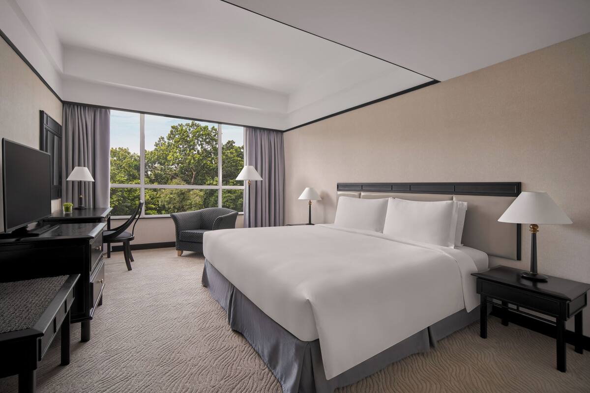 Een moderne hotelkamer met een groot bed, een bureau en een stoel.