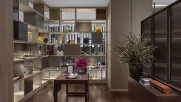 A modern interior with a wooden floor, built-in shelving units, and a central table with a vase of flowers.