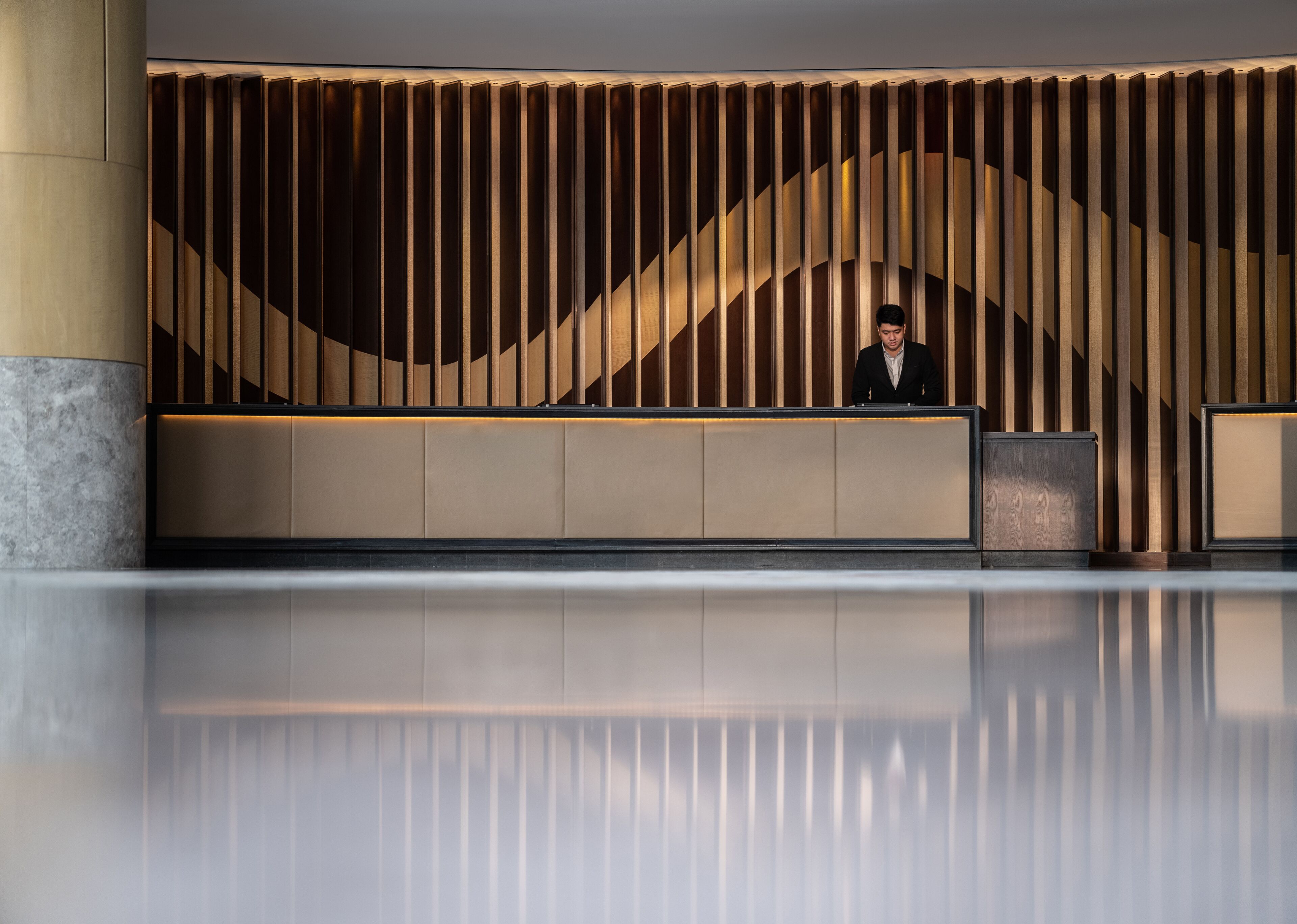 Een receptiebalie met verticale houten lamellen en een modern ontwerp.