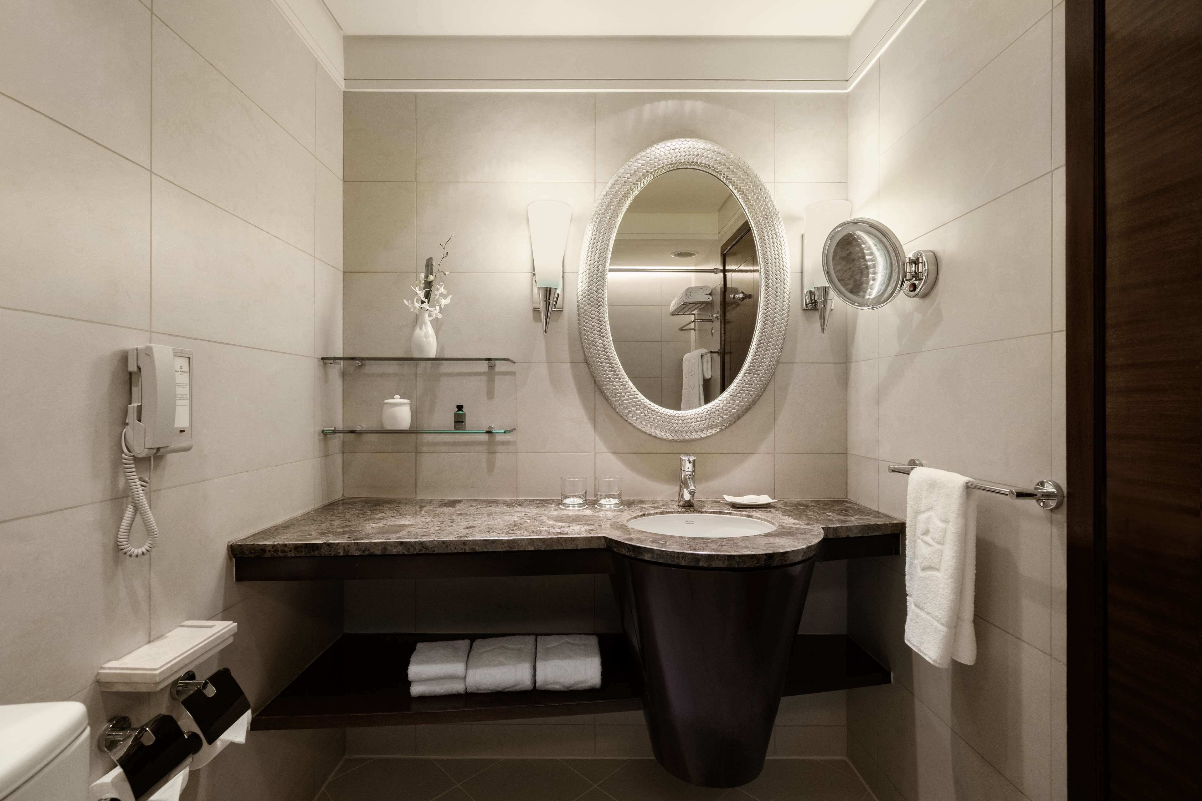 A modern bathroom with a vanity, sink, and mirror.